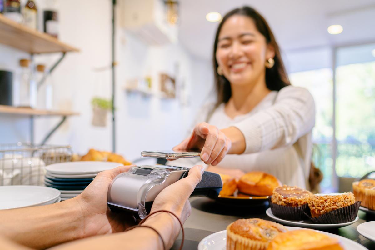 A woman paying for breakfast with her phone